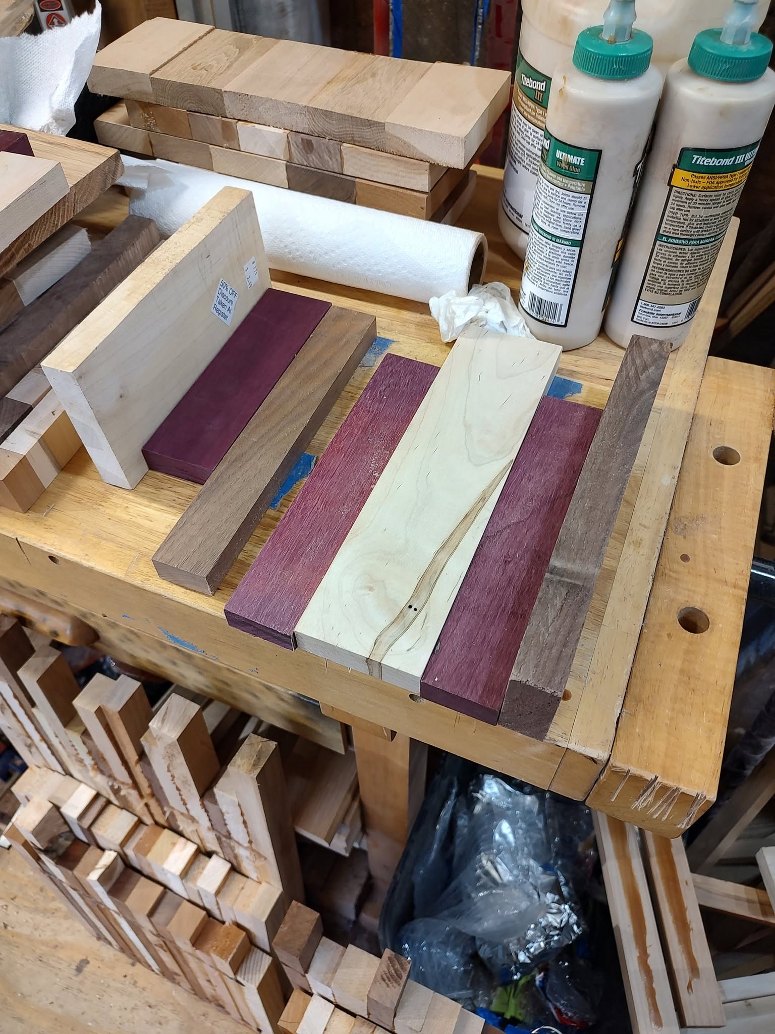 Contrasting hardwood strips arranged on the workbench before assembly